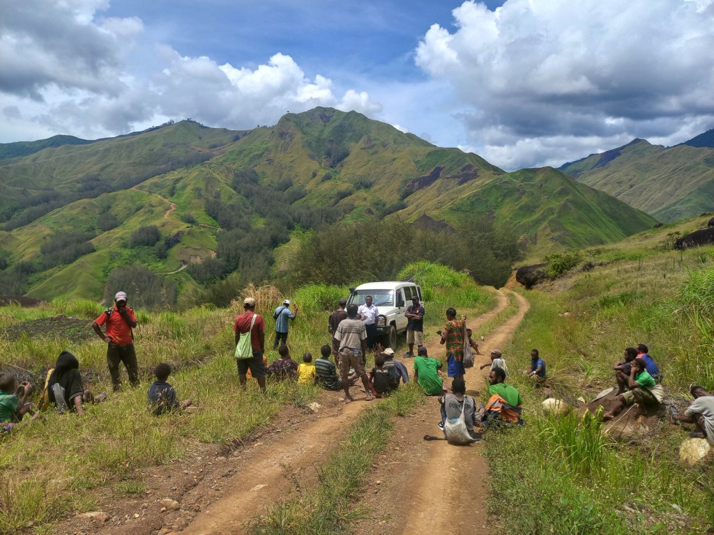 A group gather on a mountain road